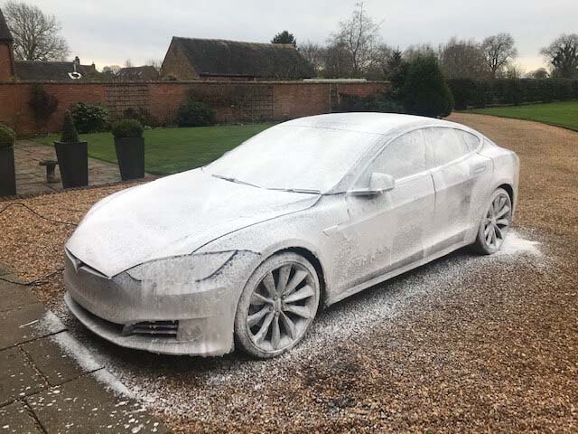 A Tesla covered in snow foam